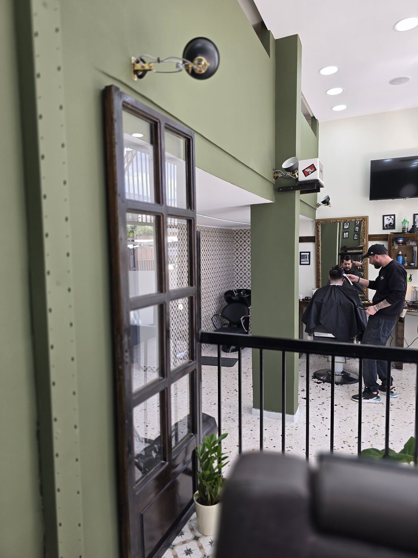 Η είσοδος, με τον κουρέα στη δουλειά στο βάθος